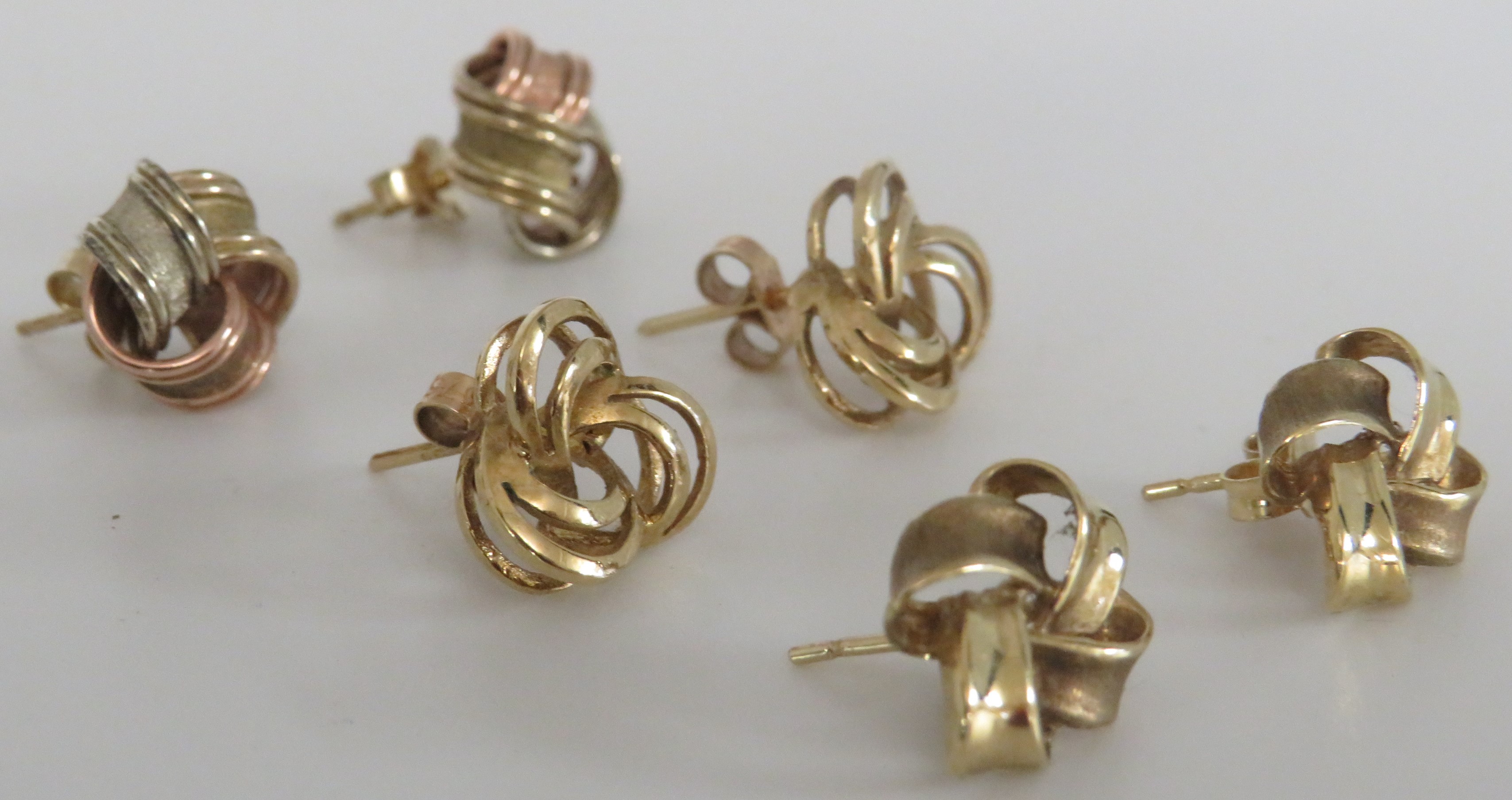 Three pairs of gold earrings - a pair of two-tone 9 carat gold knot earrings (combined 3.5g), a pair