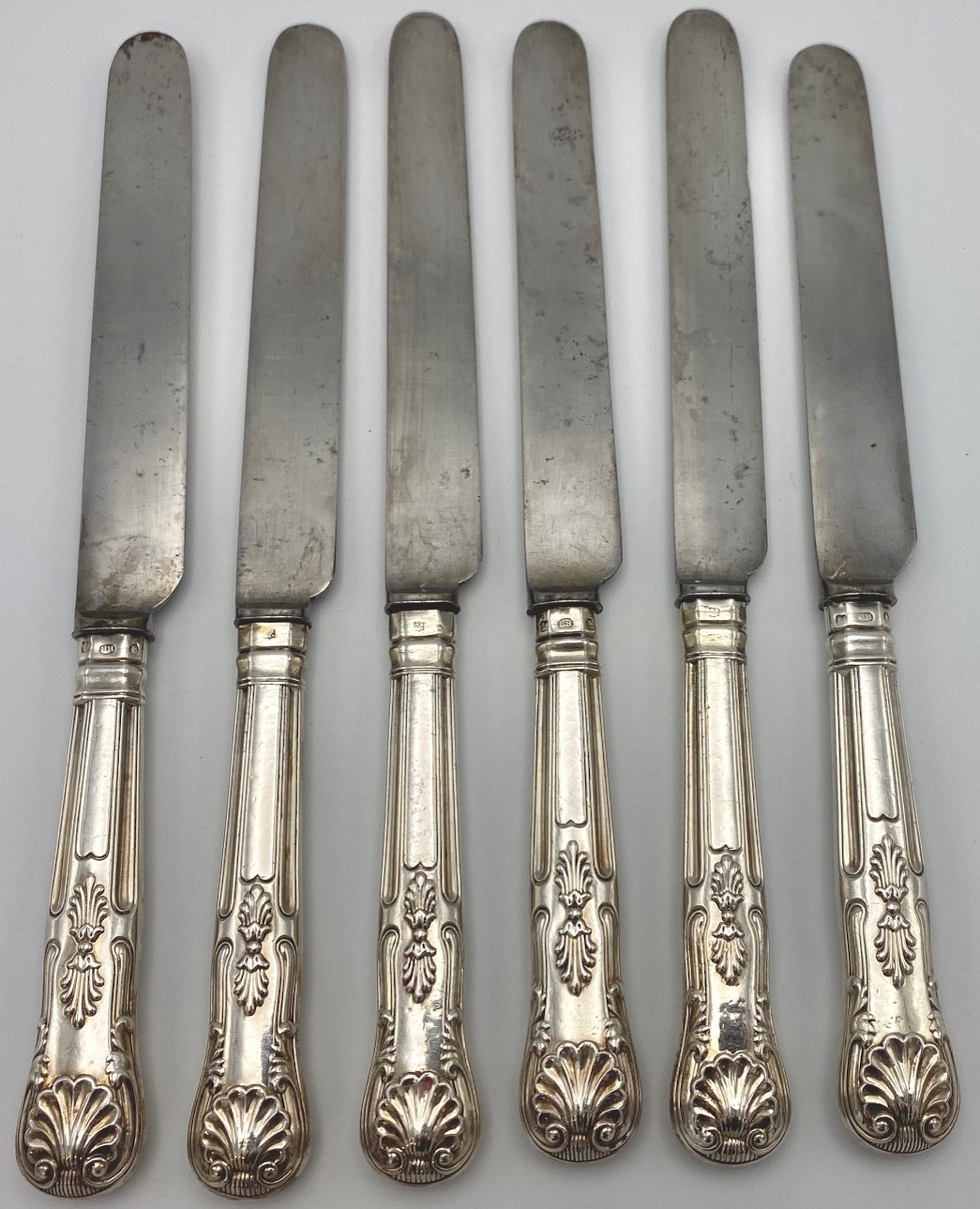 Six Victorian steel dinner knives with silver clad Kings pattern handles engraved with arms of crown