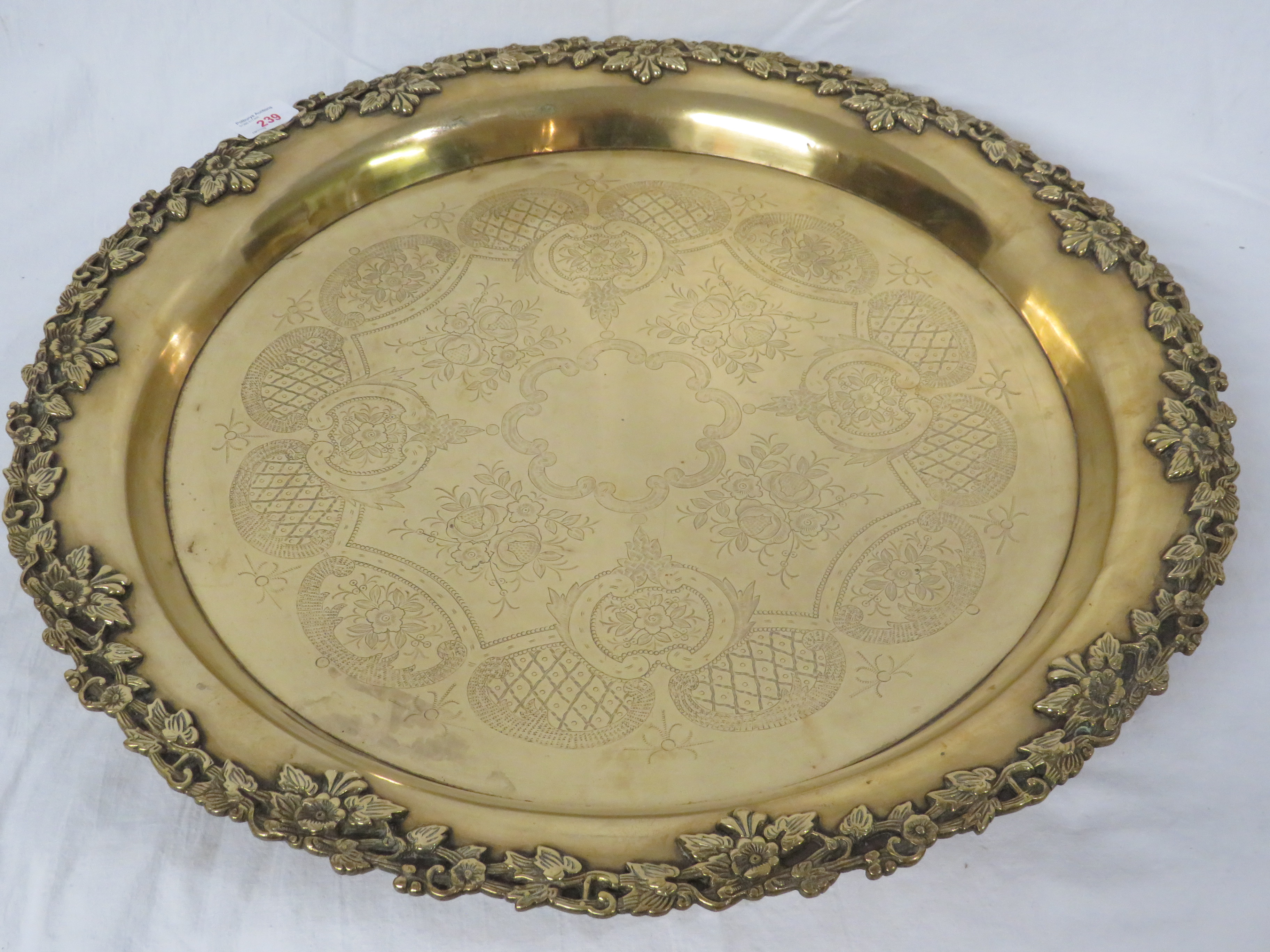 Large circular brass tray standing on four feet, the edge moulded with leaves and flowers, the - Image 2 of 3