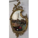 Gilt gesso cartouche mirror with bevelled glass, foliage and scrollwork to the frame and moulded