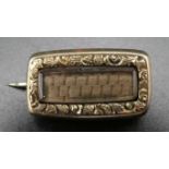 A small rectangular mourning brooch set with platted hair in a chased yellow metal mount, 16mm x 7mm