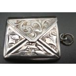 Edwardian silver stamp case modelled as an envelope and chased with vine leaves with a vacant