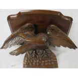 A single-shelf mahogany wall bracket raised and supported on a carved oak eagle, overall height