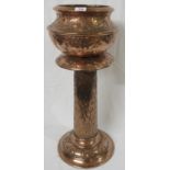 A copper jardiniere on stand, the jardiniere or planter as a bowl with expressed hammer work and a