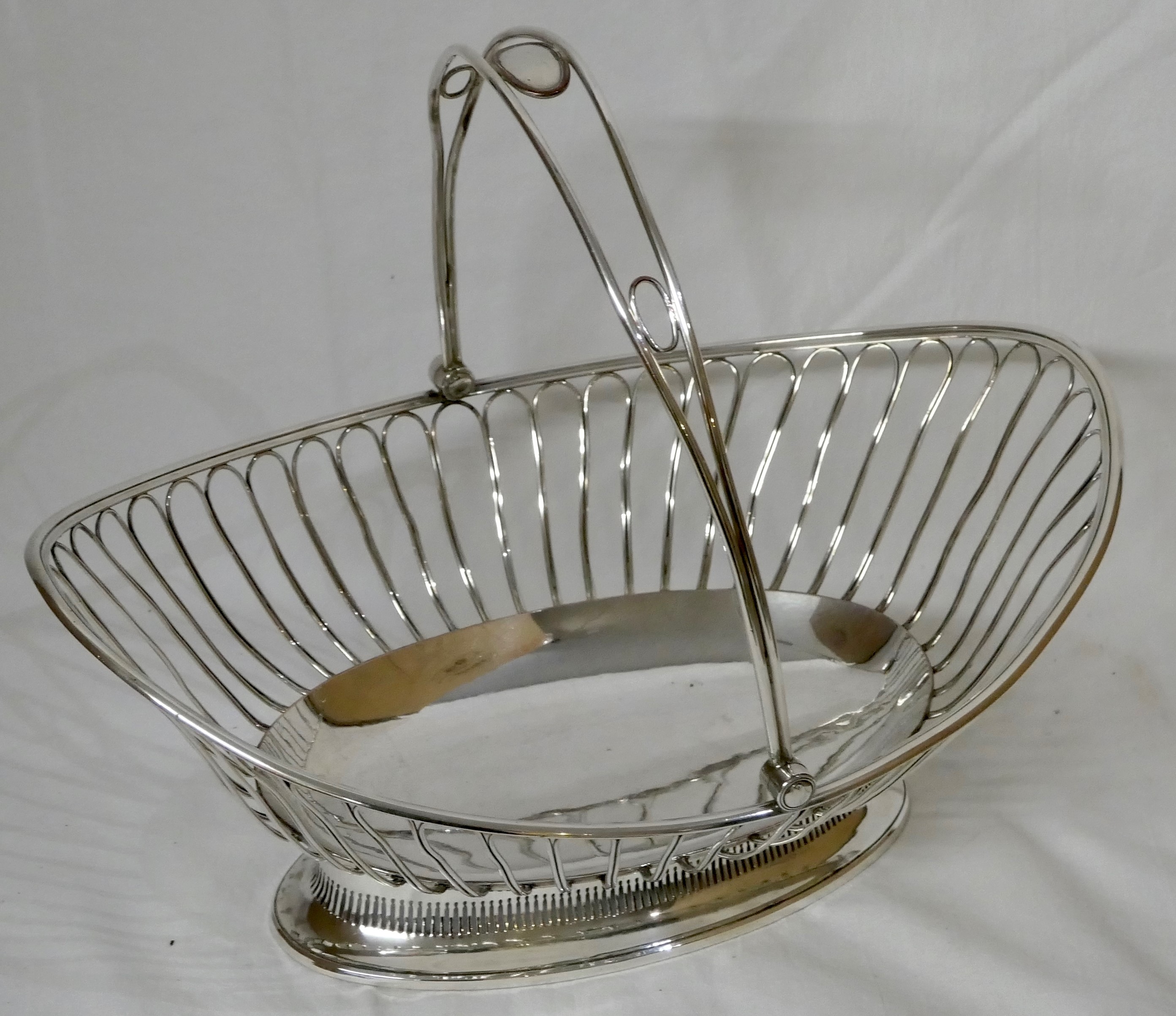 Silver-plated oval basket with hinged handle, the bowl with wire looped sides, on an oval pierced