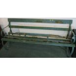 A wooden slatted garden bench with scrolled wrought metal ends, painted green, height 80cm, length