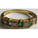 18 carat gold ring set with a row of five small emeralds and four small diamonds, the emeralds