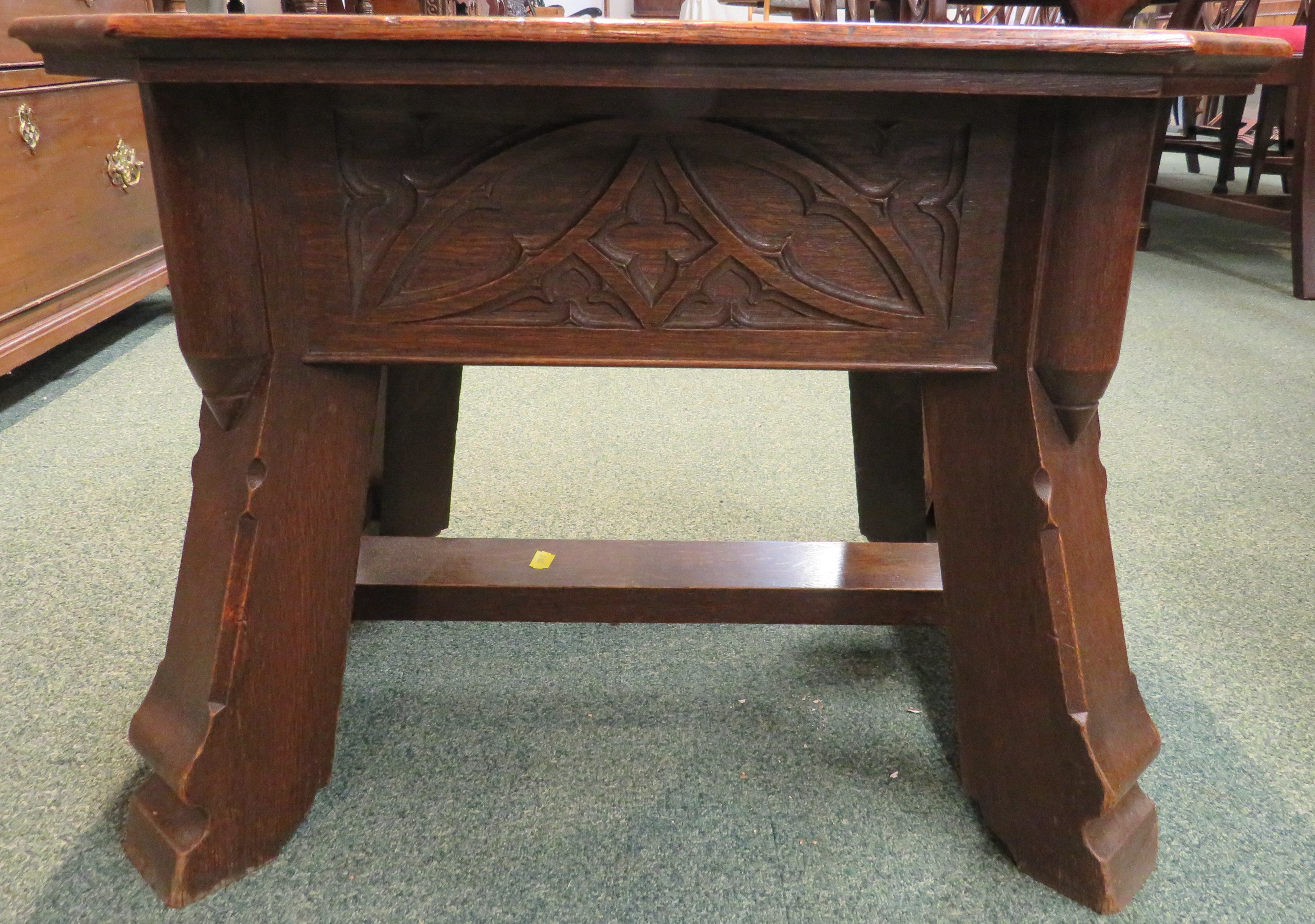 Gothic style oak stool with foliate carving to the frieze and stout stretchered out swept legs, - Image 2 of 5