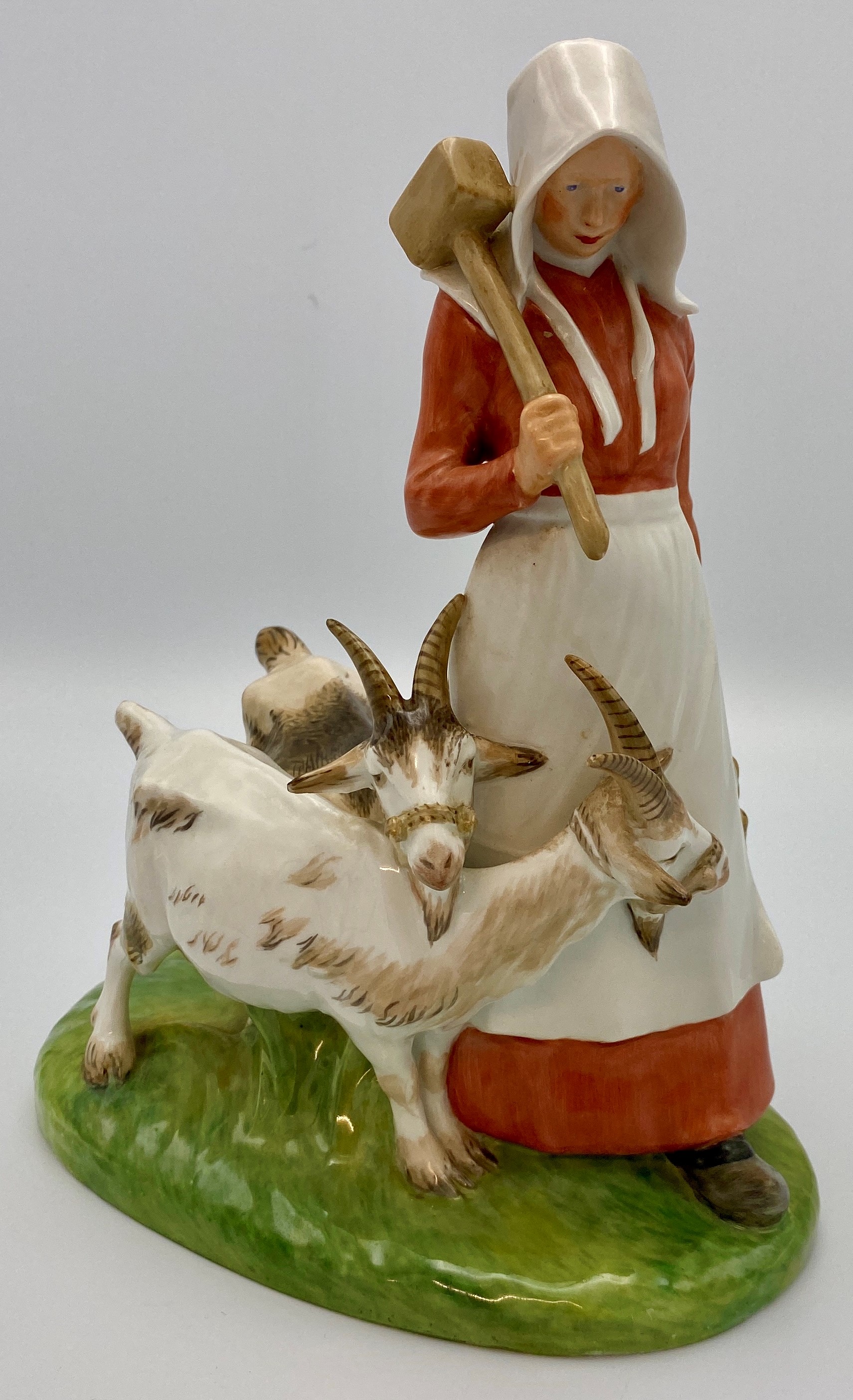 Royal Copenhagen porcelain group of woman with mallet and two billy goats, the woman in red dress,