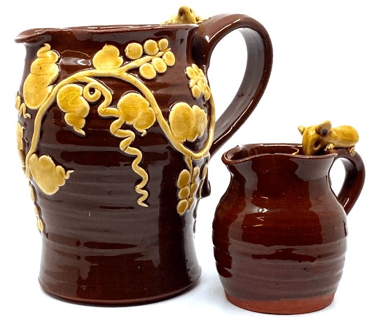 Cleverly Pottery milk jug in a treacle glaze with applied vine leaves and mouse (height 14cm), and a