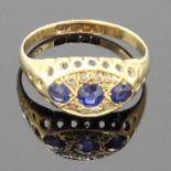 18 carat gold ring set with a line of three graduated sapphires in an oval setting with eight chip
