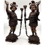 Pair of bronze Blackamoor candle holders, each modelled as a robed man holding a lamp staff and