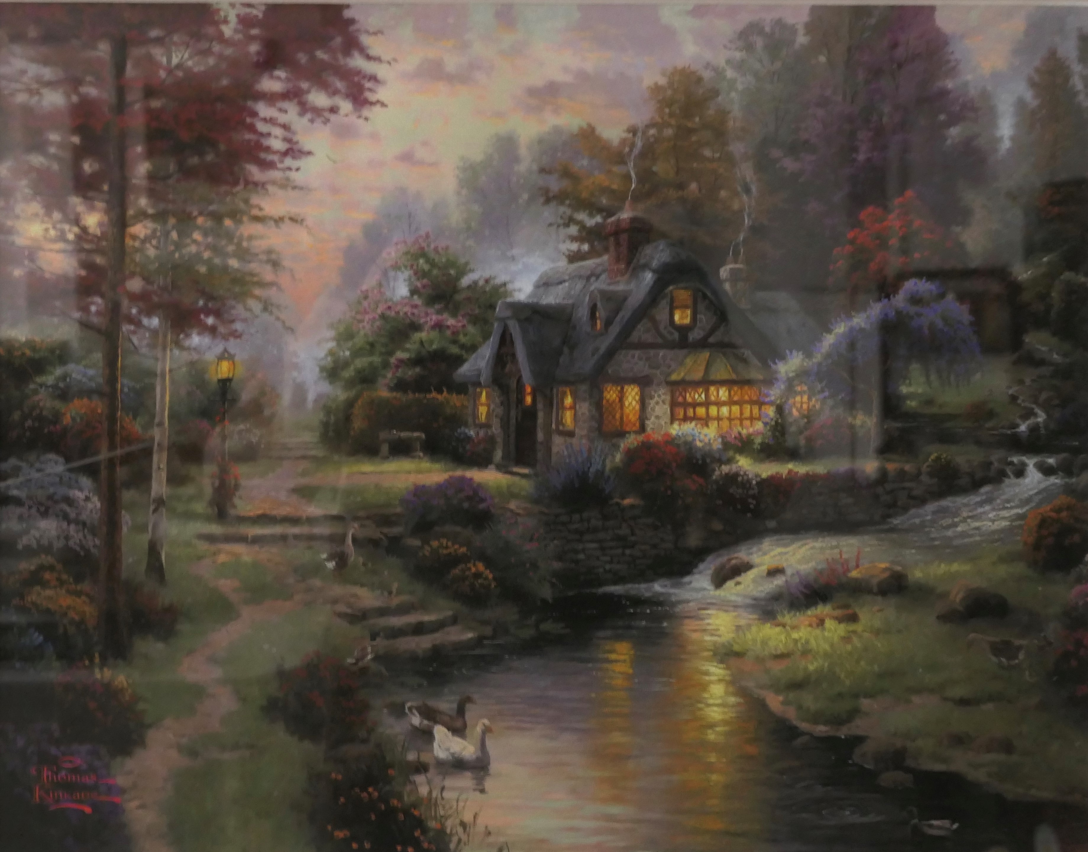 After Thomas Kinkade (1958-2012) - reproduction print of cottage and stream with swans, (27cm x