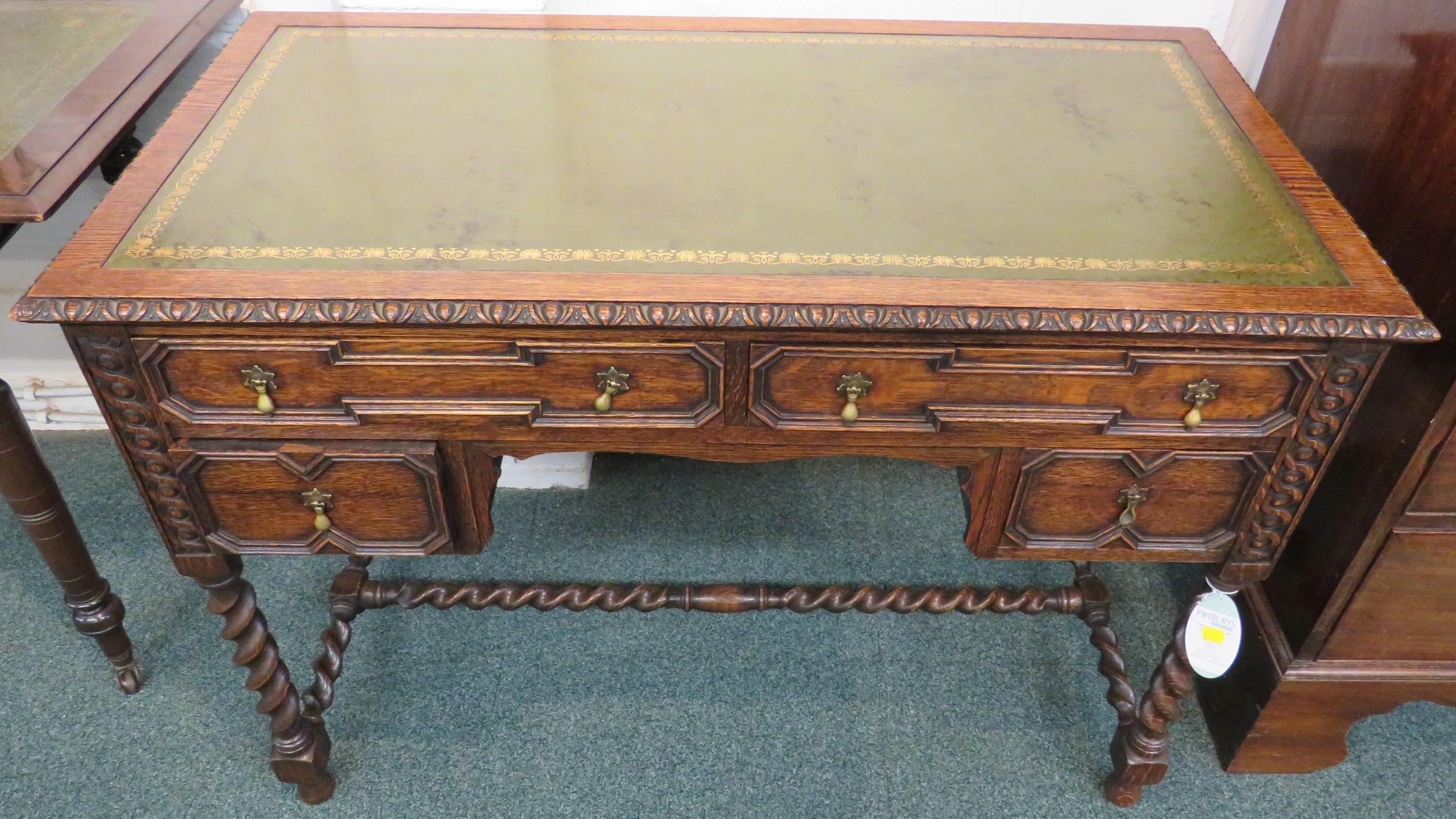 Oak desk on spiral turned legs and stretcher, the top with green leather scriber with embossed