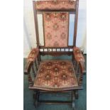 Edwardian mahogany framed rocking chair with pink upholstery to the eat, back, neck and arm rests,