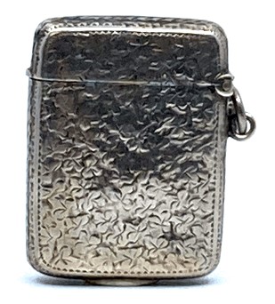 A Victorian silver vesta engraved with clover leaves and set with a yellow metal escutcheon engraved
