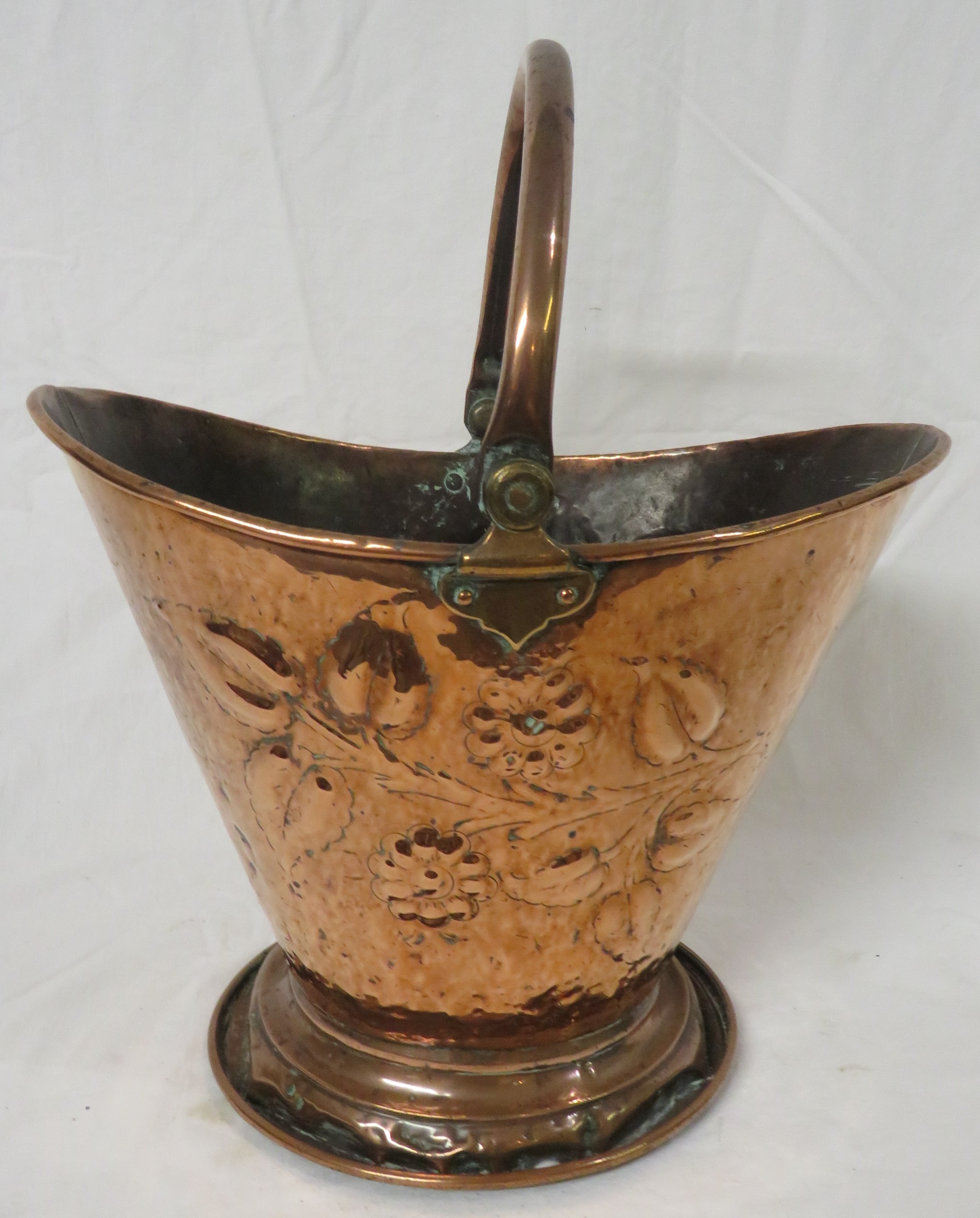 Art Nouveau copper coal bucket of cowl shape on a circular foot with hinged handle, the sides with