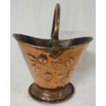 Art Nouveau copper coal bucket of cowl shape on a circular foot with hinged handle, the sides with