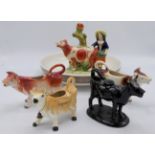 Four cow cream jugs, a Staffordshire pottery group of woman and cow (height 19cm), and a Next