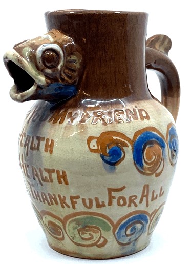 Baron Ware Barnstaple pottery motto jug with fish head spout and fish tail handle, "GOOD WISHES TO