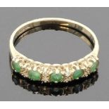 A 9 carat gold ring set with a line of five small emeralds (each about 2.5mm x 2.5mm) spaced by four