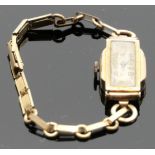 An Art Deco style lady's mechanical wrist watch with 9 carat gold case, a rectangular silvered