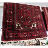 RED GROUND WOVEN FLOOR RUG WITH FOUR MEDALLIONS AND TASSELLED ENDS