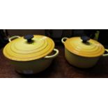 TWO LE CREUSET YELLOW ENAMELLED CAST IRON COOKING POTS WITH LIDS