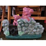 PAINTED COMPOSITE STONE FIGURAL GROUP OF PIGS BY STONE WALL