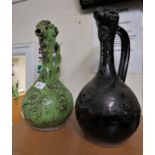 TWO GLAZED POTTERY JUGS, BOTTLE-SHAPE WITH SLENDER NECKS, FLORET MOULDINGS AND STYLIZED POURERS