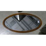 An oval bevel edged inlaid wall hanging mirror