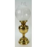 A brass oil lamp base with glass chimney and glass shade.