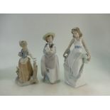 A collection of Nao porcelain figures including Girl holding puppies,