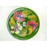 Walter Moorcroft wallplaque decorated in the hibiscus design on green ground,