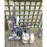 Vintage Kirby vacuum cleaner with attachments and cleaning products,