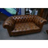 Chesterfield Settee: Chestnut brown leather Chesterfield settee