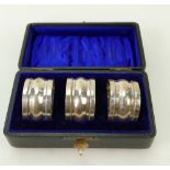 Cased silver Napkin rings: Three hallmarked serviette / napkin rings, Birmingham 1898,