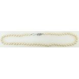 String of cultured pearls: Single strand pearls with white metal & diamond clasp.