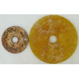 A Chinese Liuli bi disc plus one other: Disc of circular form in yellow/orange colour, diameter 21.