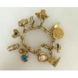 15ct gold bracelet with twelve various 9ct & 15ct charms attached, 31 grams.