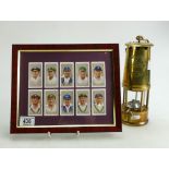 A brass Eccles miners lamp and Players Cricketer cigarette cards mounted in frame.
