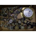 A large collection of military cap badges: plus a reproduction brass ships porthole style clock.