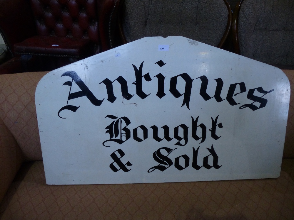A wooden sign 'Antiques bought and sold'