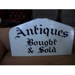 A wooden sign 'Antiques bought and sold'