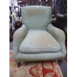 A Victorian Howard style deep seated armchair on turned fron legs