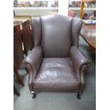 A modern brown leather living armchair on cabriole legs