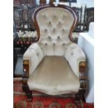 A Victorian mahogany button back armchair on turned front legs