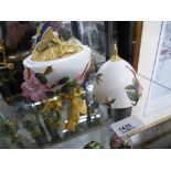 A David Fryer studio fine bone china decorative egg, encrusted with flowers and a gilt legs in the