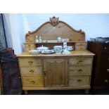 An Old stripped pine sideboard with central cupboard lunch raised back on turned legs 138cms