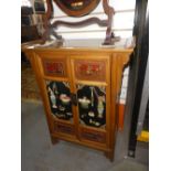 A decorative Oriental cabinet with raised and relief decorated doors and side panels